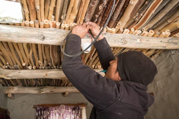 A man works to install electricity in a Himalayan village.