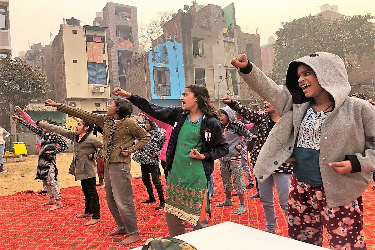 A group of girls in a settlement in Delhi, India, practising self-defence techniques outdoors.