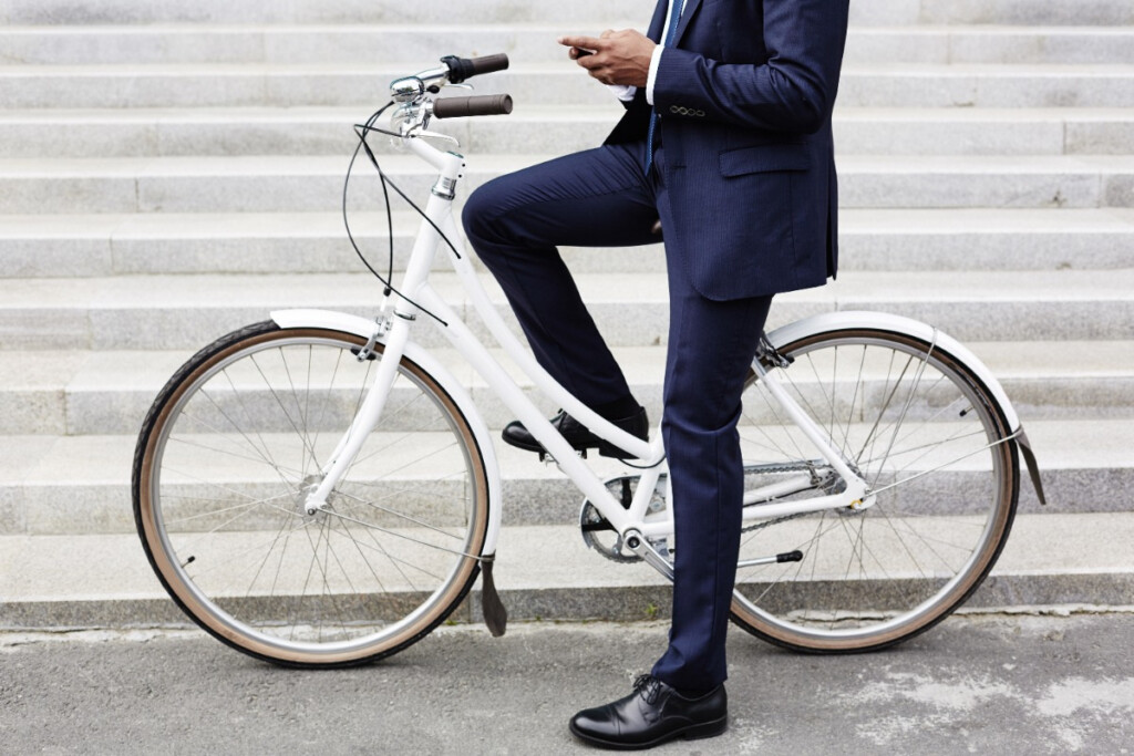 A person in a suit on a white bicycle symbolises eco-friendly commuting and sustainable transport.