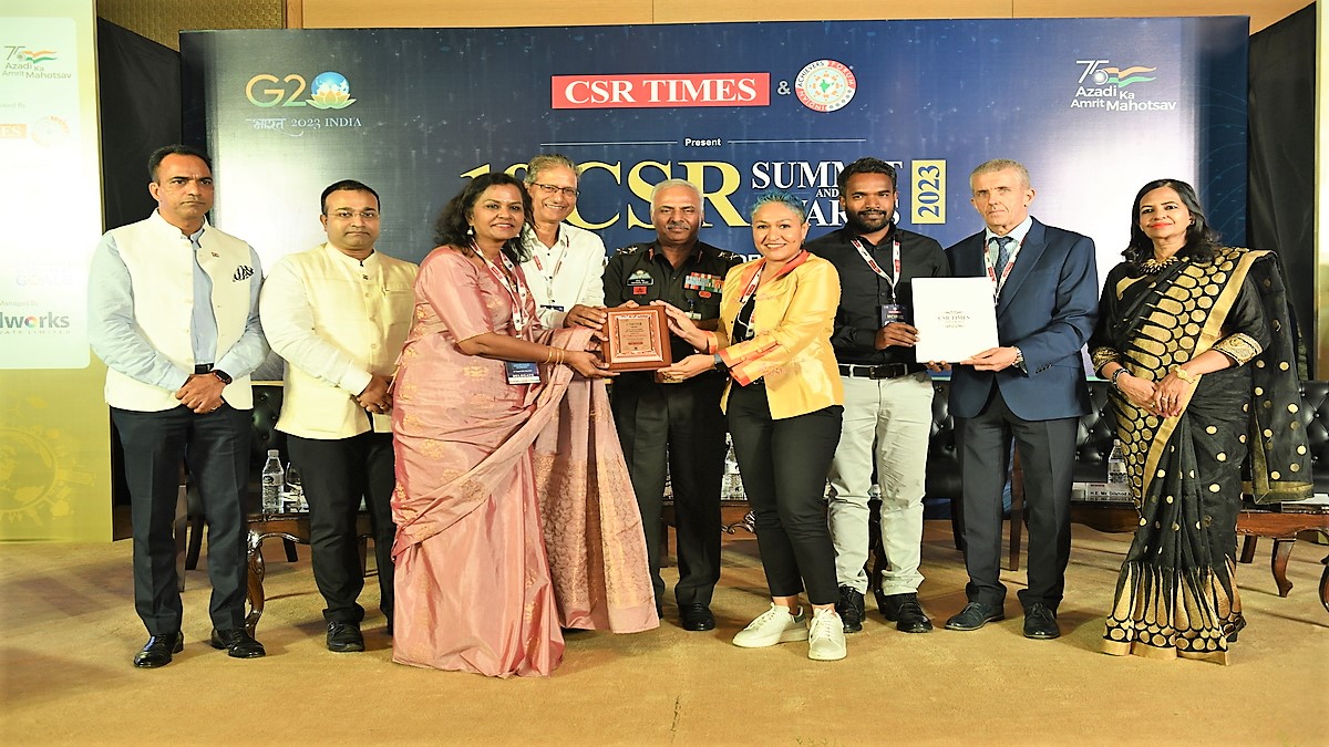 A group of people pose for an award presentation.