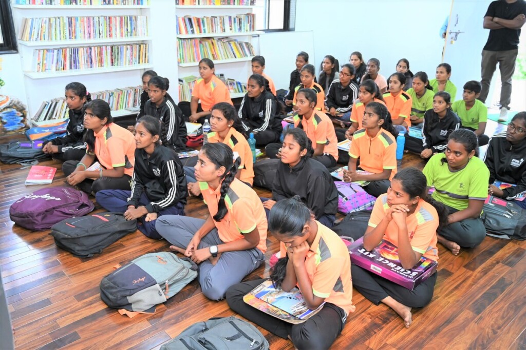 A group of young female students attentively listen during a learning session in India.