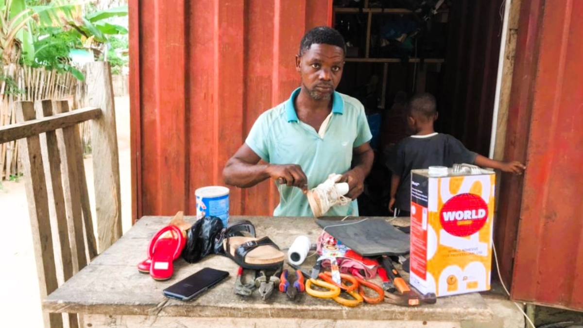 A hearing-impaired shoemaker in Ghana working at his workshop.