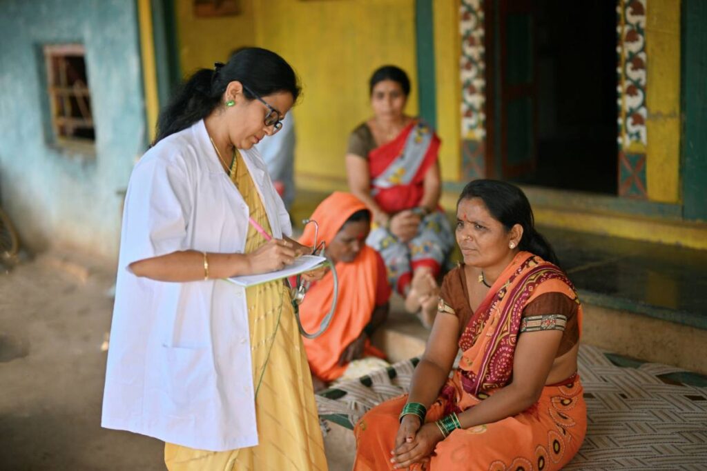 A doctor provides medical assistance to a member of a rural community.