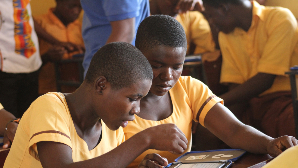 Two youths with disabilities in a Ghanaian classroom focused intently on their studies.