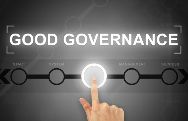 A hand clicking a good governance button on a touch screen.