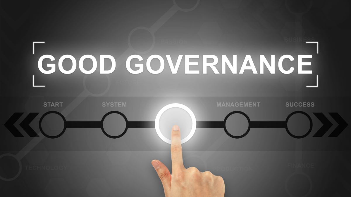 A hand clicking a good governance button on a touch screen.